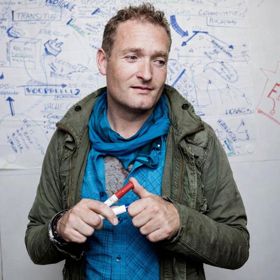 Portret van Arjan Postma voor een whiteboard vol schetsen
